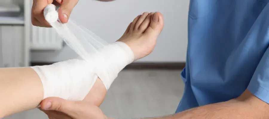 Bandage being rolled around a foot by a healthcare practitioner
