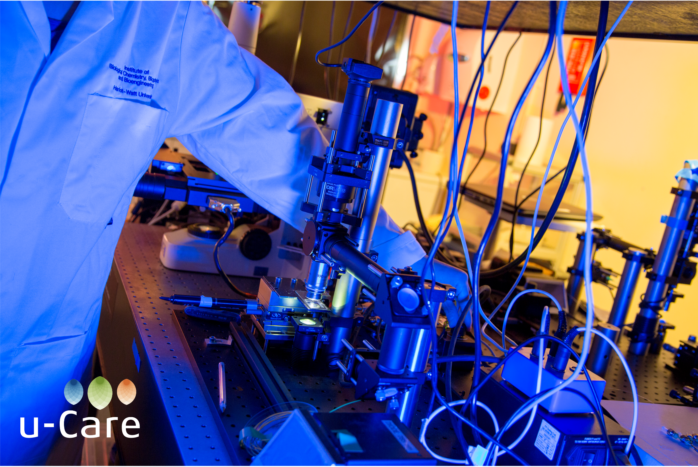 Scientist in lab coat using fibre optic laser technology